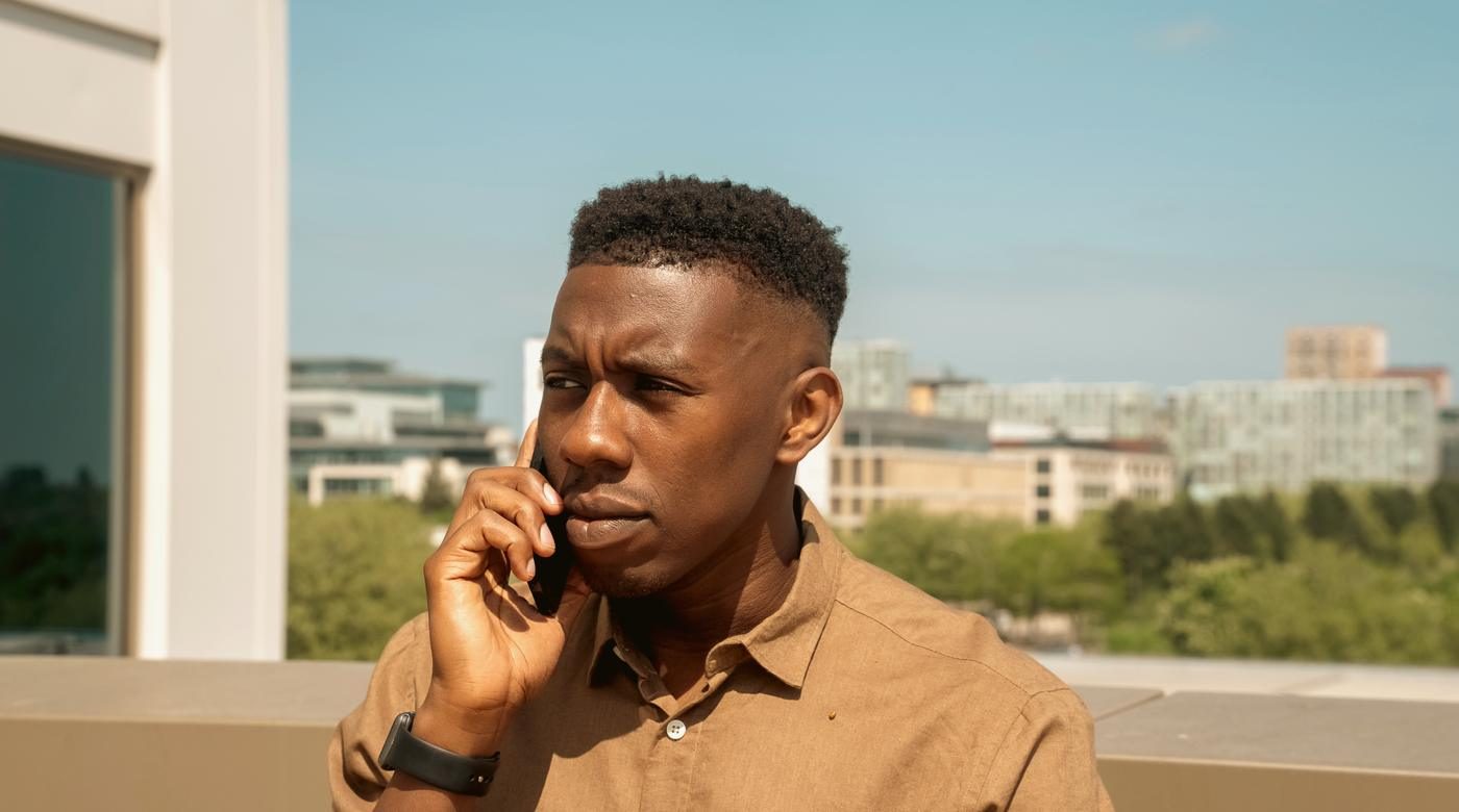 A man taking a call outdoors, on his own.