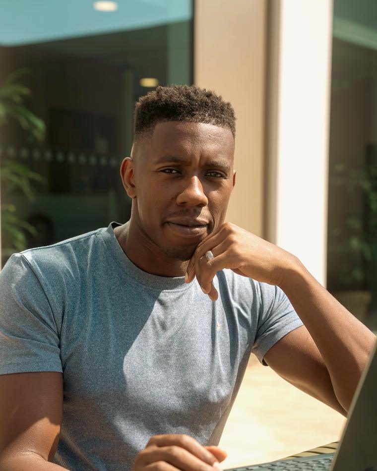 John Obidipe at a laptop, looking up from the screen.